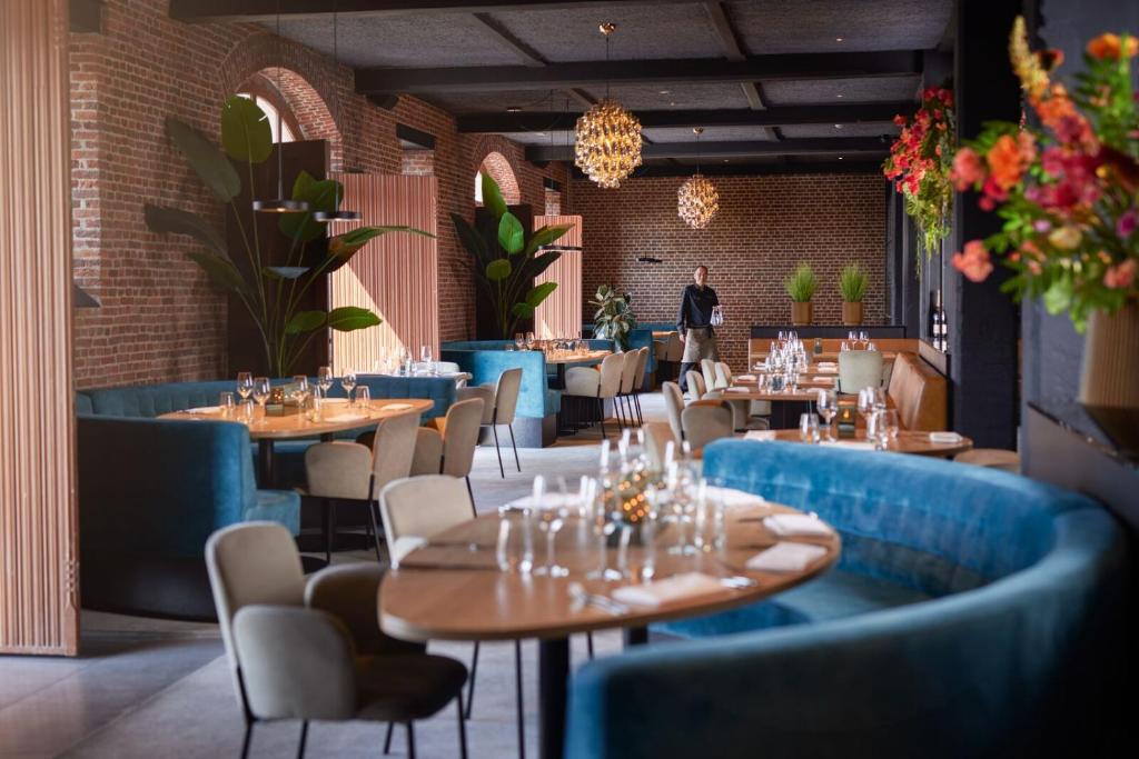 Restaurant with exposed brick and blue banquettes at Van der Valk Hotel Mechelen